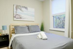 a bedroom with a white bed with a window at JstLikeHome - Central Suite in Ottawa