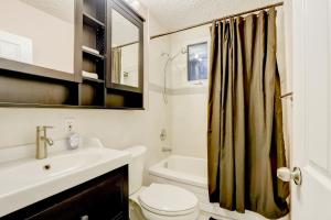 a bathroom with a toilet sink and a shower curtain at JstLikeHome - Central Suite in Ottawa