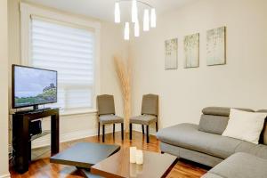 a living room with a couch and a tv at JstLikeHome - Central Suite in Ottawa