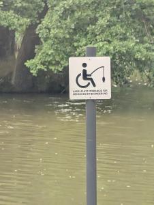 a sign on a pole next to a body of water at Natur Camping Rabu in Radeburg