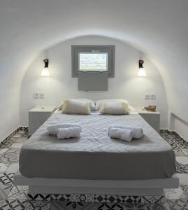 a bedroom with a large bed with two pillows on it at Giasemi Fira Studios in Fira