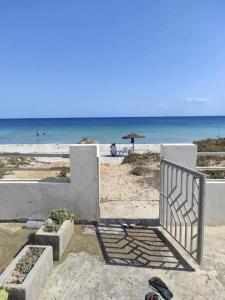 a gate on a beach with the ocean in the background at Waterfront house 1 in Kelibia +7 photos