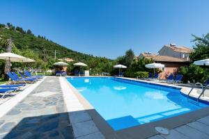 a large swimming pool with chairs and umbrellas at Lemon Garden Apartments in Lygia