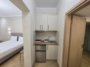 a small room with a bed and a sink and a kitchen at Pension Alexandra in Parga