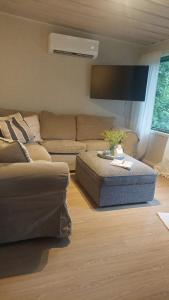 a living room with a couch and a table at En mysig liten Stuga nära naturen och havet in Västlax