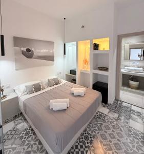 a bedroom with a large bed with two towels on it at Giasemi Fira Studios in Fira +10 photos