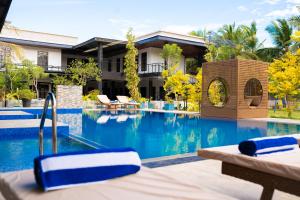 a resort swimming pool with chairs and a house at Aathi Resort in Trincomalee