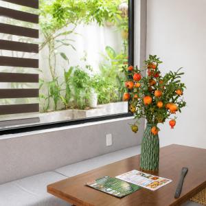 a vase of oranges on a table in front of a window at Lacasa Homestay in Hue +18 photos