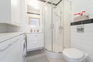 a white bathroom with a shower and a toilet at Apartament Prowansalski in Nałęczów +17 photos