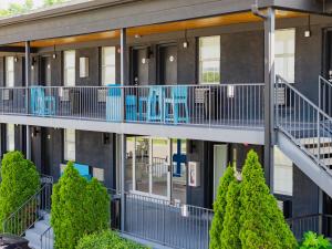 an exterior view of a building with blue balconies and trees at The Iris Motel in Nashville