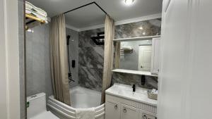 a bathroom with a tub and a sink and a mirror at Yuzhnaya in Qyzylorda +29 photos