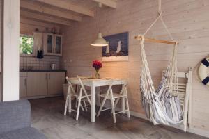 a kitchen and dining room with a table and chairs at Marynarskie Domki in Pobierowo