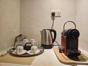 a counter top with a coffee maker and coffee cups at The Villa Luxury Suites Hotel in Diani Beach +57 photos