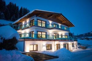 a large house with snow around it at night at Villa Valentine in Flachau