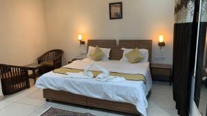 a bedroom with a bed with two towels on it at narayana regency in Ludhiana