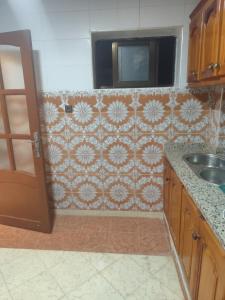 a kitchen with a sink and a tiled wall at Aroui aireport in Nador Airport