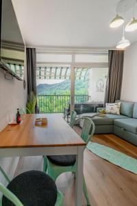 a living room with a table and a couch at MOOKI Sky by Lake in Villach