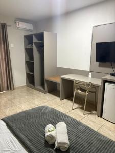 a room with a desk and a table with a desk at Quefren Residence Hotel in Uberaba