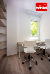 an office with a table and two chairs and a nissan sign at Domus Halo D in Pamplona