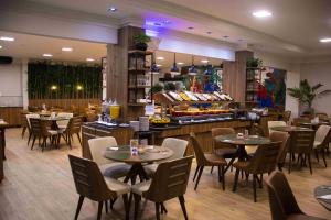 a restaurant with tables and chairs and a buffet at Cataratas Park Hotel e Eventos in Foz do Iguaçu