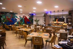 a dining room with tables and chairs and a restaurant at Cataratas Park Hotel e Eventos in Foz do Iguaçu