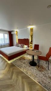 a bedroom with a large bed and a table at Yuzhnaya in Qyzylorda