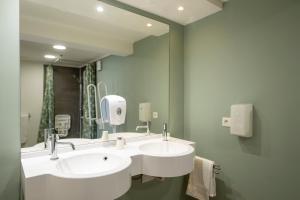 a bathroom with two sinks and a large mirror at Premiere Classe Liege / Luik in Liège