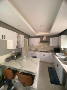 a kitchen with white cabinets and a table with chairs at Elegant 3-Bedroom Loft Condo in Kingston