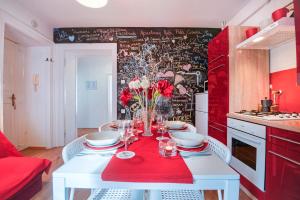 a kitchen with a white table with a red table cloth at Apartments Ruža in Pula