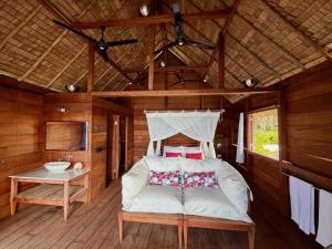 a white couch in a room with a bed at ipyum Premium Overwater Guest House in Pulau Birie