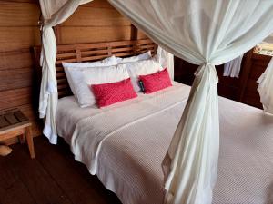 a bedroom with two beds with red pillows at ipyum Premium Overwater Guest House in Pulau Birie