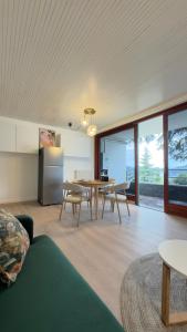 a living room with a table and chairs and a refrigerator at Riflesso Apartment in Blevio