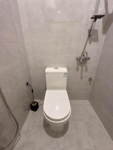 a bathroom with a white toilet and a shower at Hail View شقق فيو حائل المخدومة in Hail