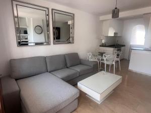 a living room with a couch and a table at Adosado en residencial in Mijas Costa
