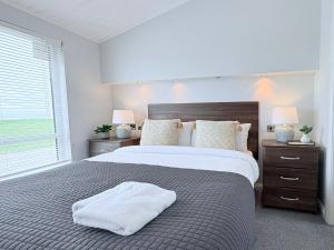 a bedroom with a large bed and two night stands at Sea View Retreat Lodge in Heysham