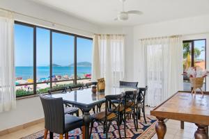 a dining room with a table and chairs and the ocean at Hotel Palace 1 in Florianópolis