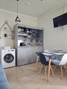 a kitchen with a table and a washing machine at Elina House and Garden in Nikiti