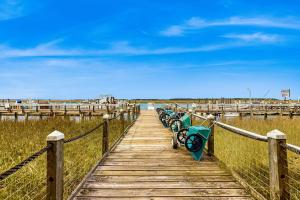 a wooden boardwalk with a row of benches on it at Bay Creek Villa - 311 in Edisto Beach