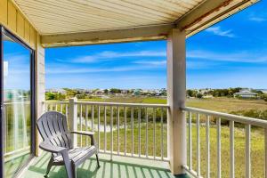 a rocking chair on a porch with a view of the ocean at Bay Creek Villa - 311 in Edisto Beach