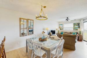 a dining room and living room with a table and chairs at Bay Creek Villa - 311 in Edisto Beach +23 photos
