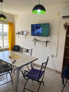 a room with a table and chairs and a tv on the wall at Casa en la Punta San luis in La Punta