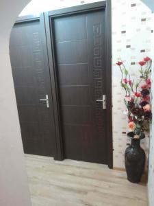a pair of black doors with a vase of flowers at ლაზები in Akhaltsikhe