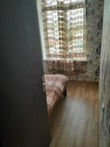 a room with a bed and a window with a curtain at ლაზები in Akhaltsikhe