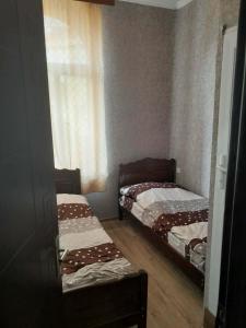 two twin beds in a small room with a window at ლაზები in Akhaltsikhe
