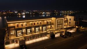 a building with lights in front of a river at night at V Beach in Jeddah