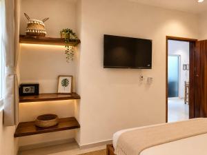 a bedroom with a bed and a flat screen tv at Hotel Isla Mujeres Centro & Beach Club Included in Isla Mujeres