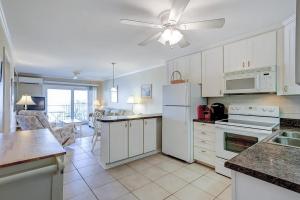 a kitchen with white cabinets and a ceiling fan at Beachwood Place 3E in Hilton Head Island