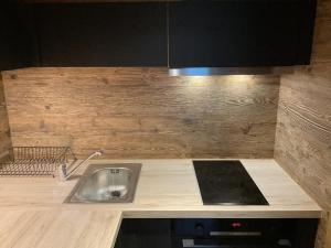 a kitchen with a sink and a stove at Le vieux chalet in La Forclaz