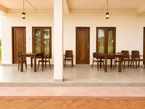 a dining room with wooden tables and chairs at The Blue Sapphire Of Wilpattu in Wilpattu