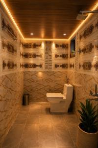 a bathroom with a toilet and a stone wall at Sky Desert Safari Jaisalmer & Spa in Jaisalmer +35 photos